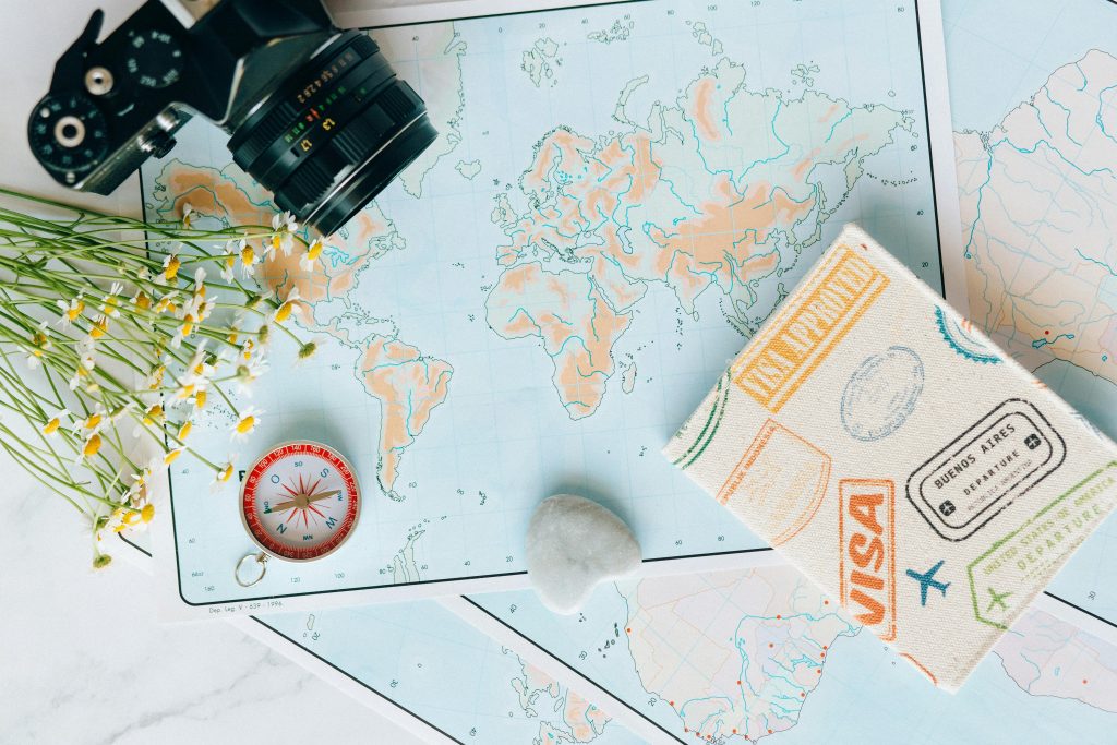 pexels-photo-7235804-7235804 Flat lay of travel essentials: maps, camera, compass, and travel journal for planning adventures.